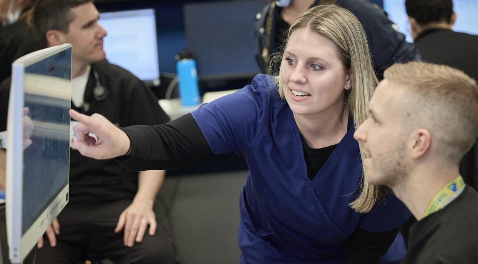 Cooper nurse pointing out something on a computer screen to a student