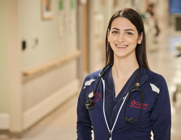Nurse smiling in hospital corridor.
