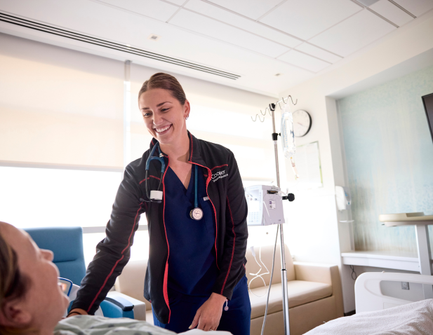 Nurse standing next to patient bed.