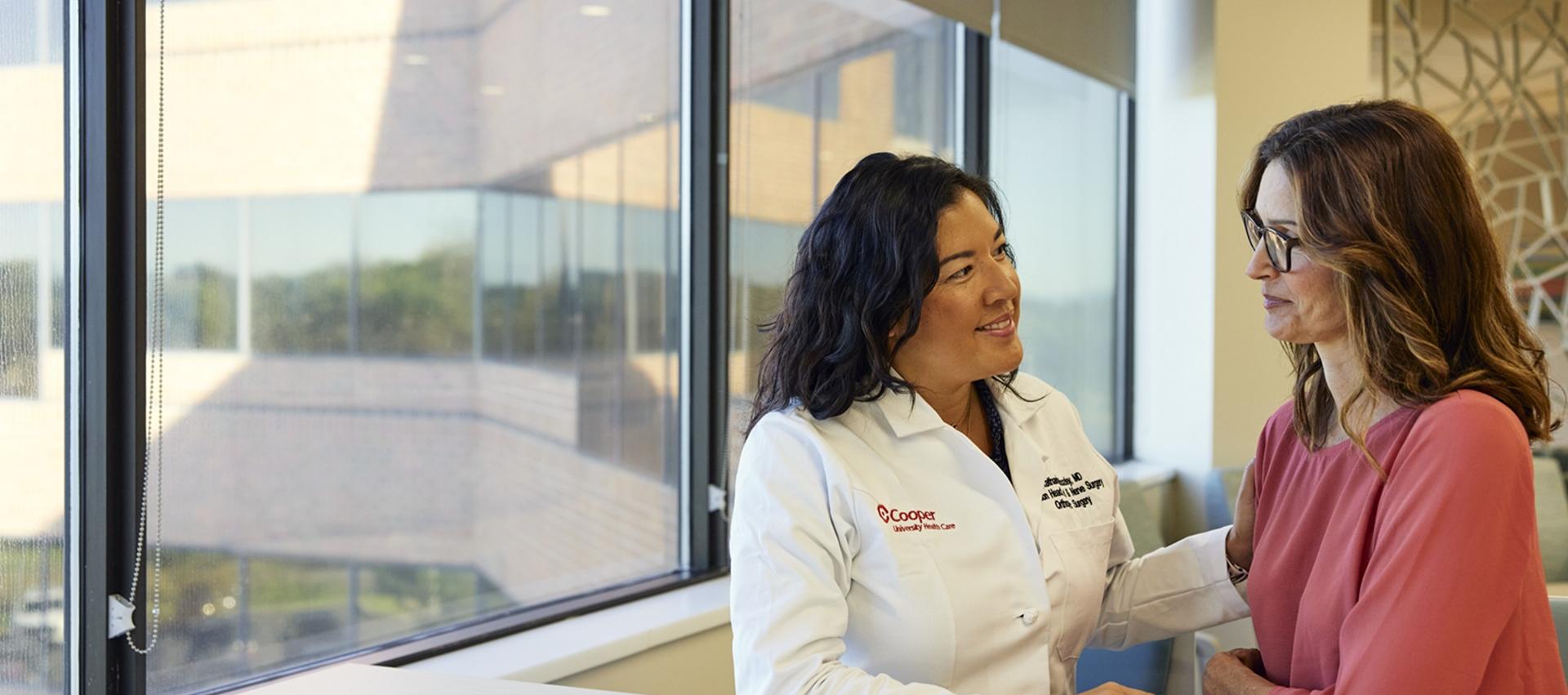 Doctor sitting with female patient at window