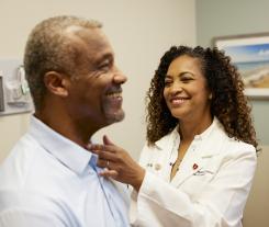 Dr. Lisa Reid gives a thyroid exam to a male patient