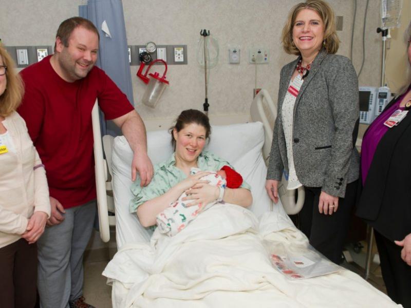 Members of the Cooper leadership team present a Little Hats kit to a new family.