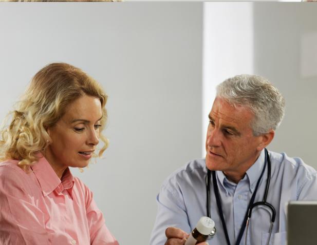 Doctor reviewing a prescription with a patient during a consultation in a medical office.