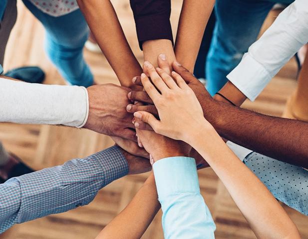 A group of people stacking their hands together in a huddle