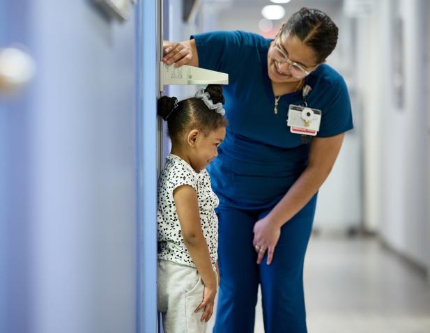measuring pediatric patient girl nurse