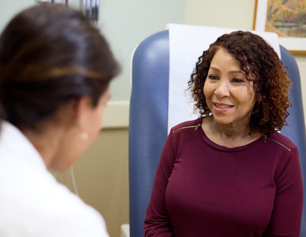 Cooper specialist speaking with female patient in an exam room