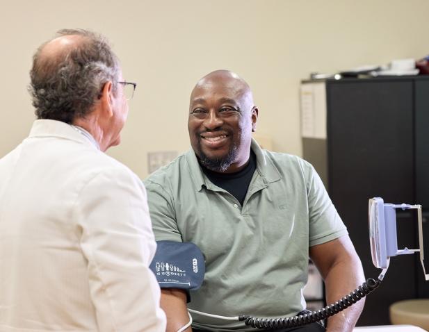 doc with heart patient blood pressure cuff