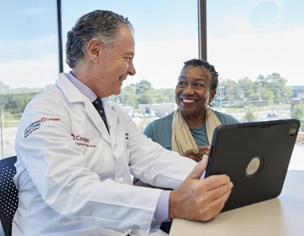 Dr. Infantolino with tablet talking with female patient 