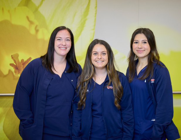 Three nurses in blue scrubs