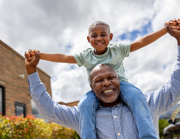 A happy grandfather with grandson outdoors.