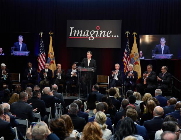 Press event for Project Imagine groundbreaking, view of speakers on stage from back of audience.