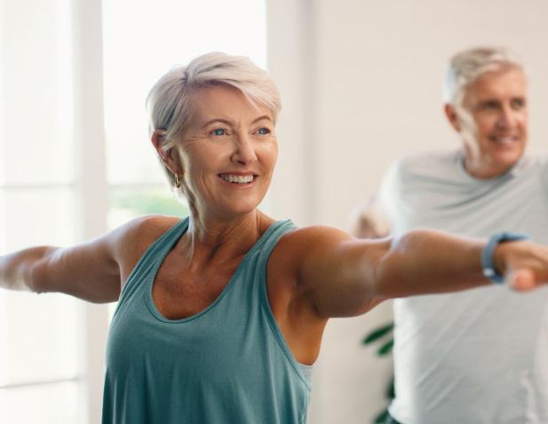 Older woman doing a yoga warrior pose.