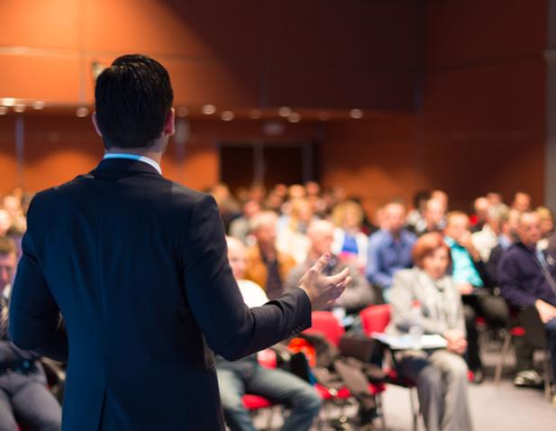 stock photo of a male presenter giving a talk to an audience