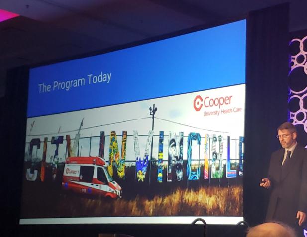 image of large presentation screen on the left and a man holding a clicker on the right