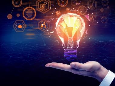 glowing lightbulb floats slightly above open palm