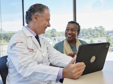 Doctor with patient reviewing records on a computer.