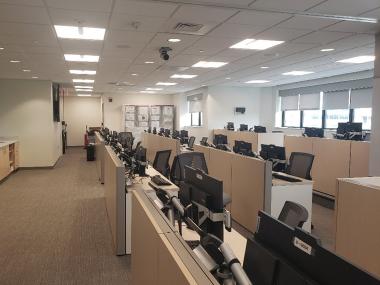 Photo of Cooper's medical coordination center showing three long rows of desks with computer monitors on each desk