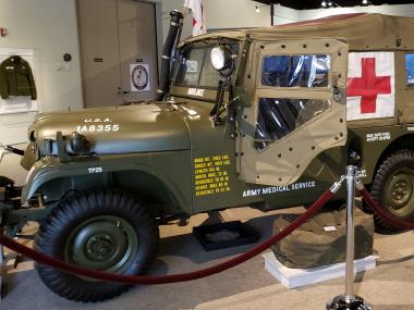 olive drab military medic jeep with red cross on its side