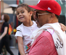 Father and daughter smiling together at an outdoor event.