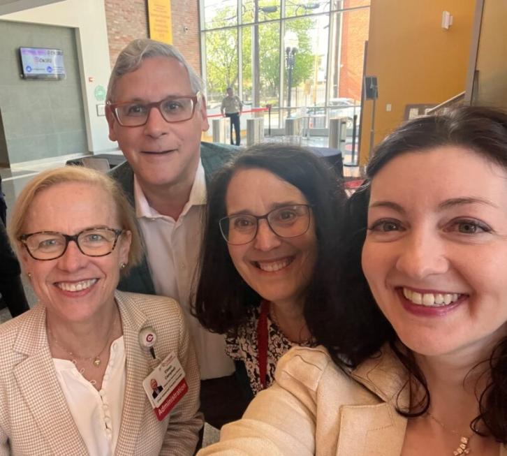 Three female and one male clinician at Women in Medicine event take a selfie